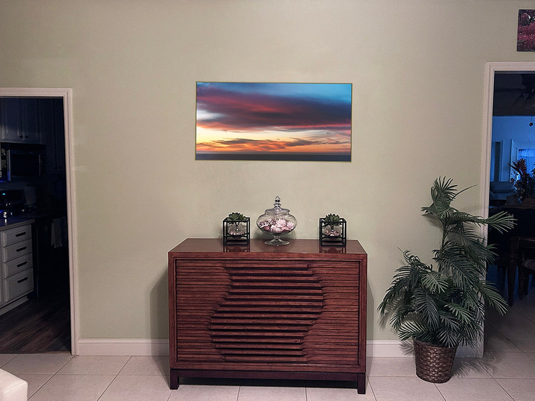Room mockup showing “Colors,” a sunset photograph, above a wooden credenza between two doorways, with a plant beside it.