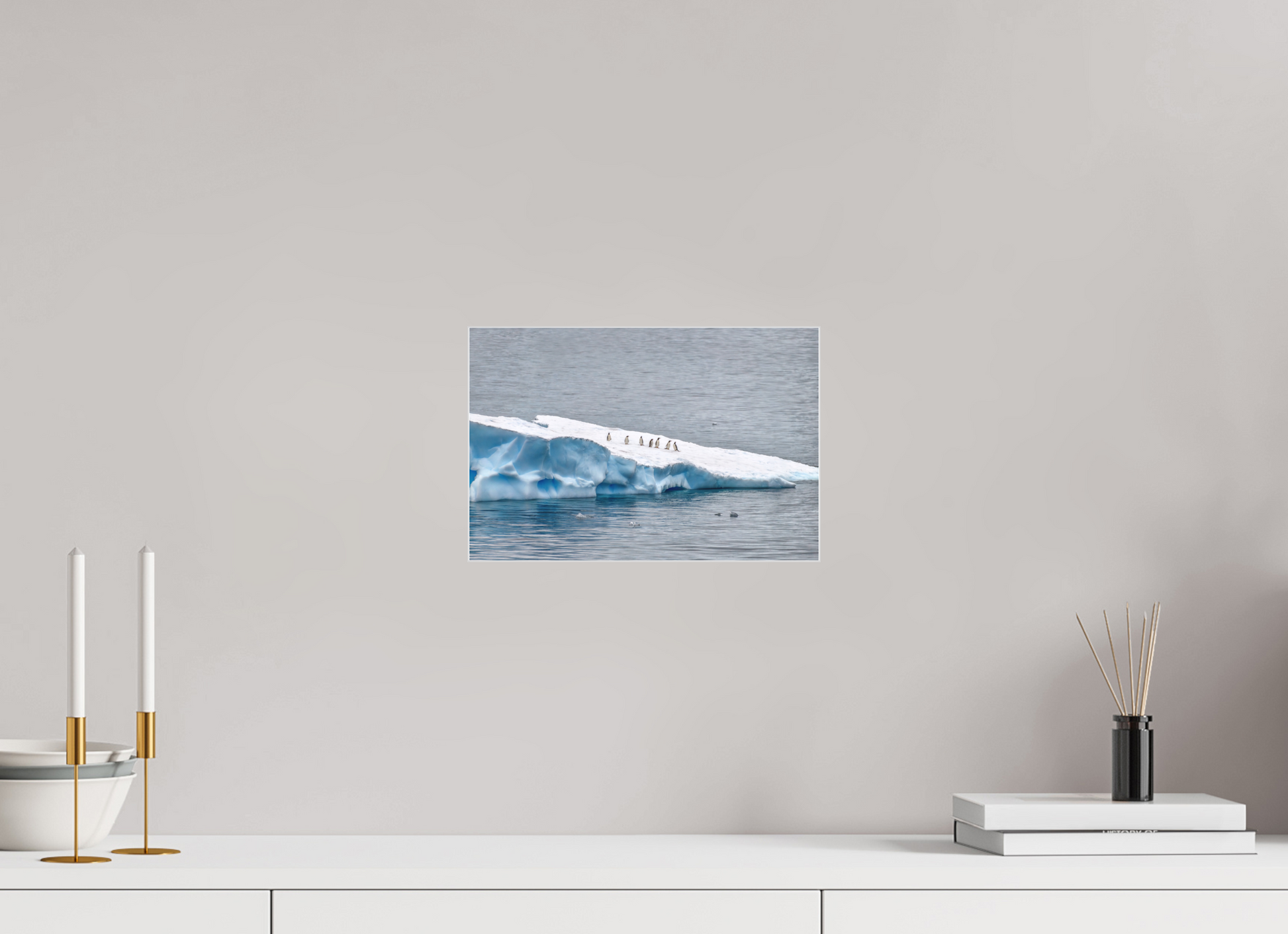 Antarctic Penguin Procession 12×8″ gallery-quality color acrylic print by Richard H Knight, displayed above a white credenza with decorative items