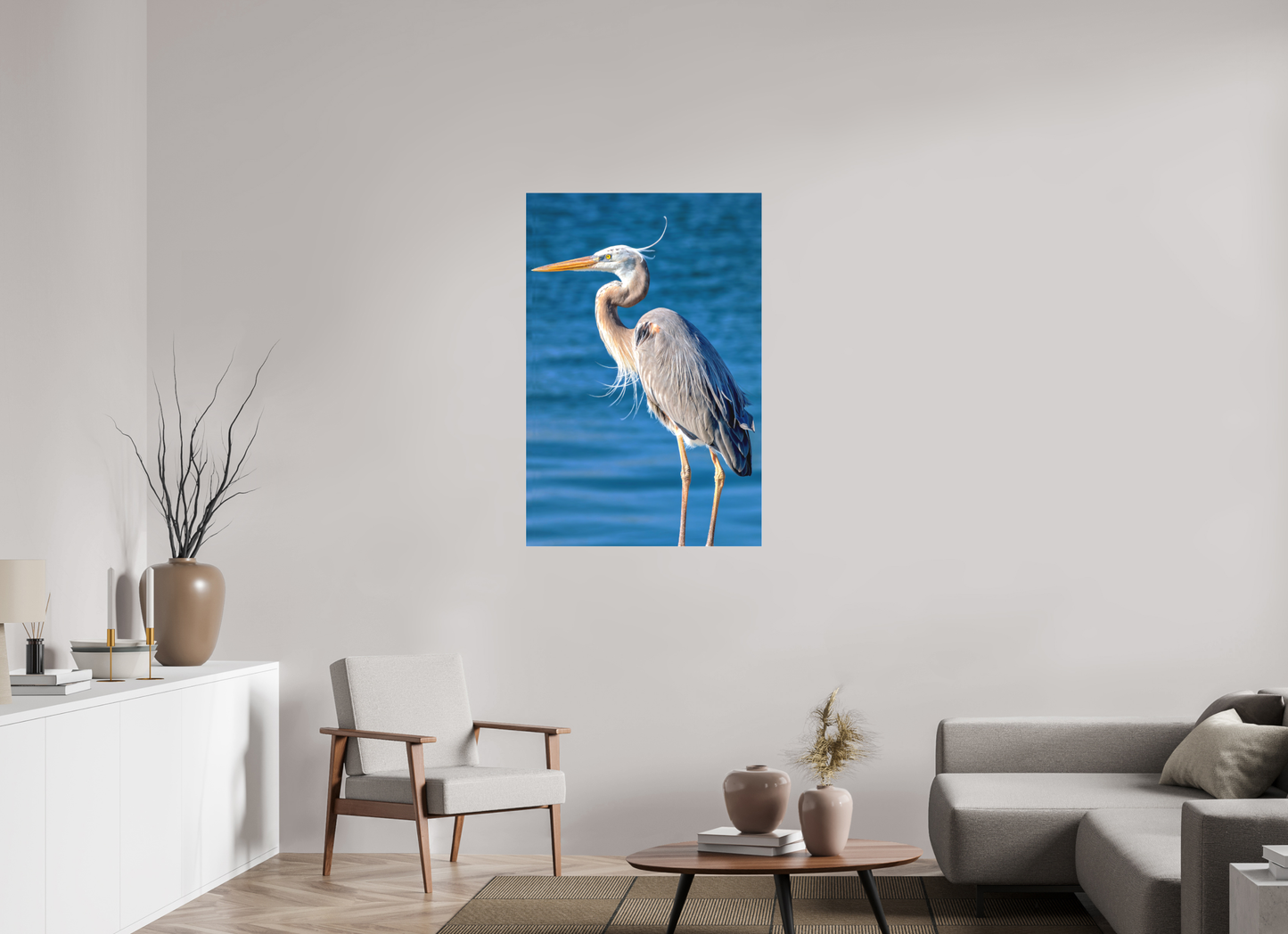 Large format, 30 x 45″ 'Standing Blue Heron' print in a slimline aluminum frame, featured in a modern living room with a designer chair and rug.