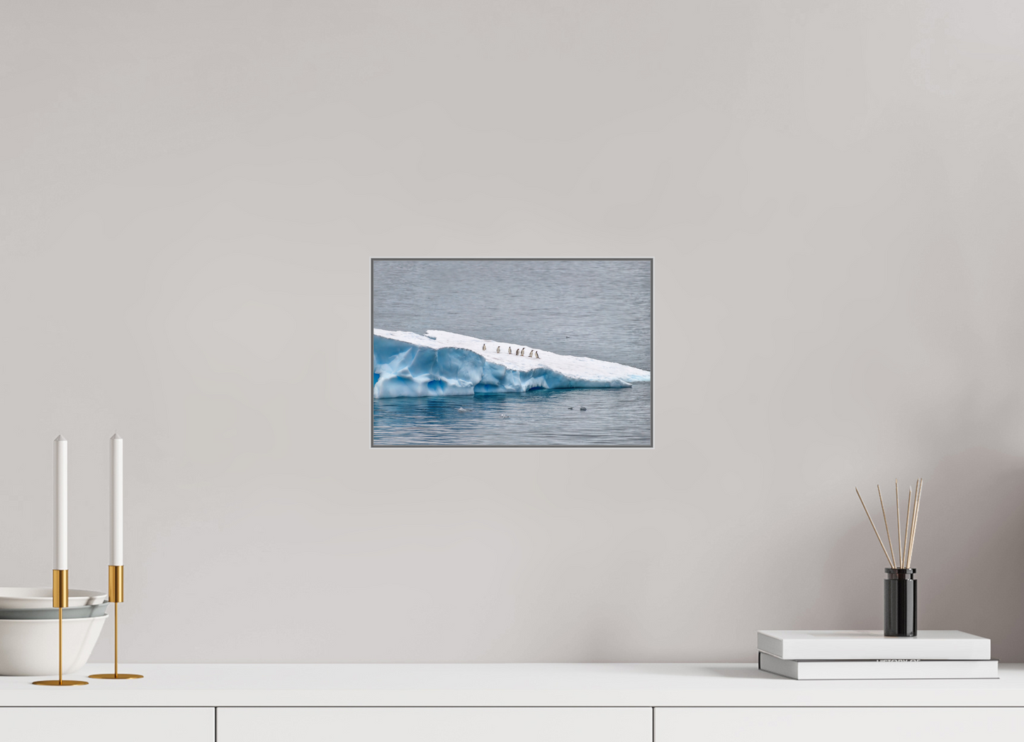 Antarctic Penguin Procession 12×8″ gallery-quality color ALDibond metal print by Richard H Knight, displayed above a white credenza with decorative items