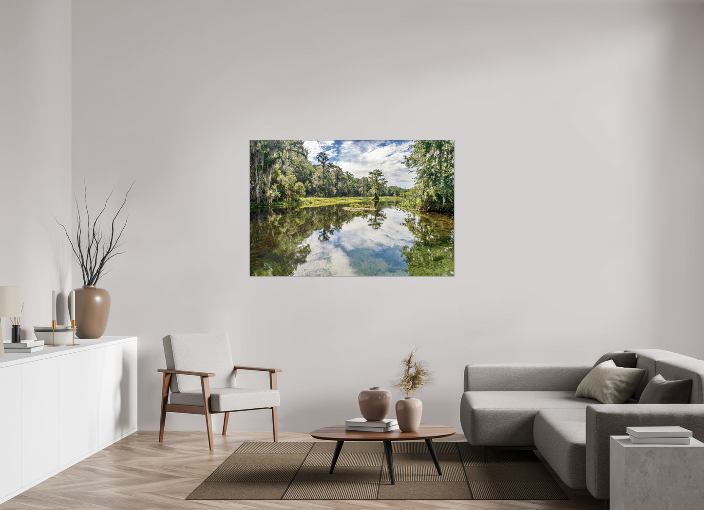 Living room with a large, framed photographic print of a lake surrounded by trees.